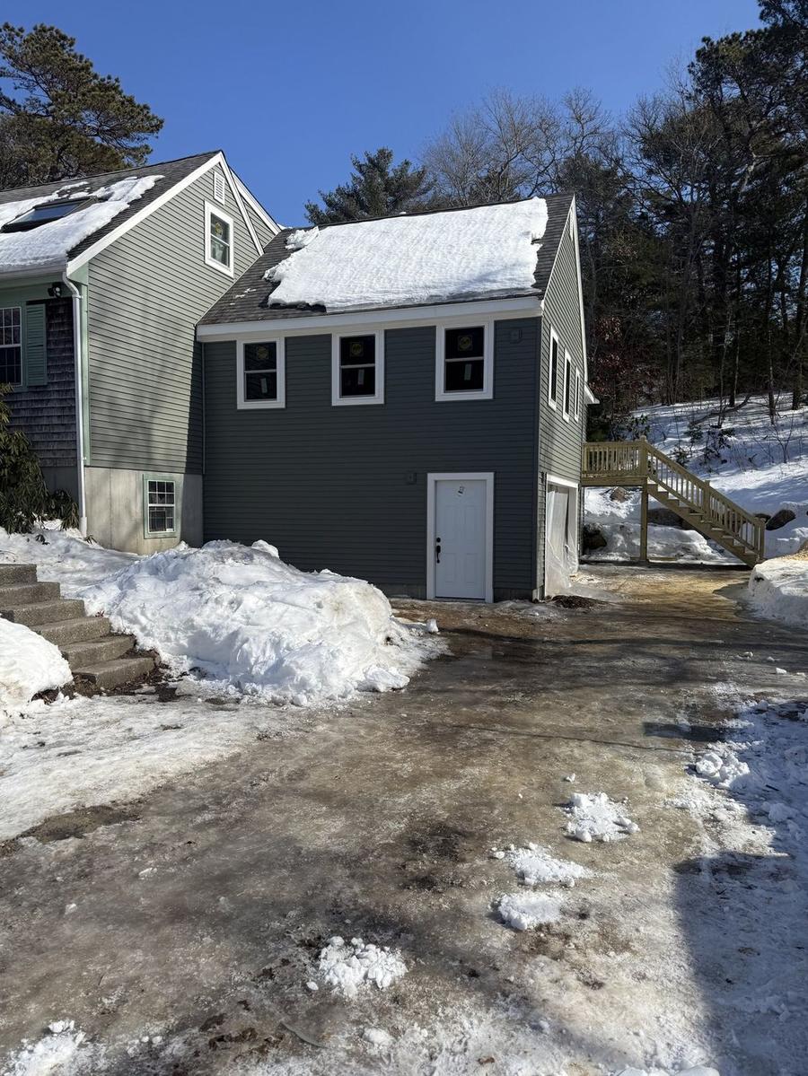 Completed two-story home addition with dark siding and custom stairway — Perocchi Building & Remodeling, South Shore MA